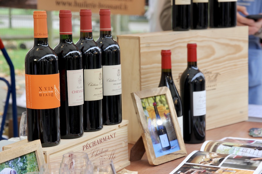 Bouteilles de vin rouge du Château Terre Vieille exposées sur le stand d'un salon du terroir